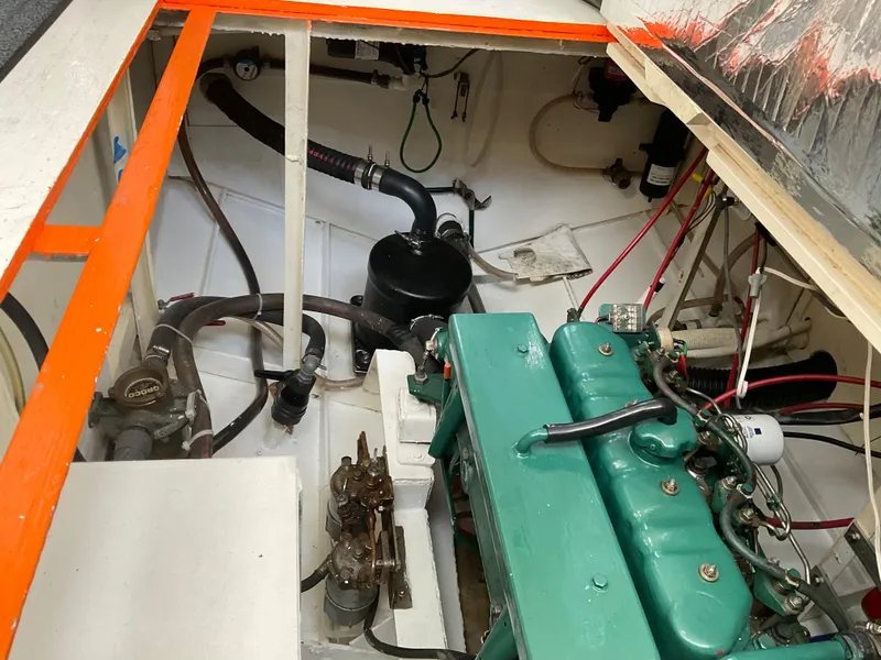 Slide: The Image of Engine compartment of a 1980 Kanter Staysail Cutter with visible green engine and wiring. - 30