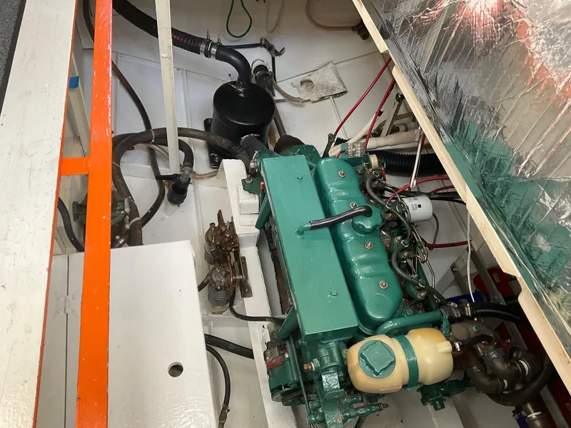 Slide: The Image of Engine compartment of a 1980 Kanter Staysail Cutter, featuring a green marine engine. - 31