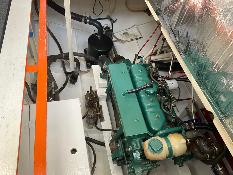 Slide: The Image of Engine compartment of a 1980 Kanter Staysail Cutter, showcasing mechanical components and wiring. - 32