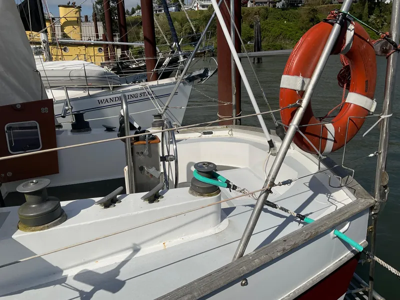 Slide: The Image of 1980 Kanter Staysail Cutter with lifebuoy, docked in a marina. - 5