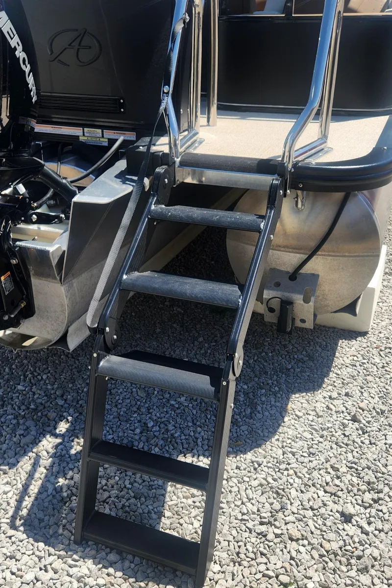 Slide: The Image of 2024 Avalon LSZ 2385 Rear Lounger boat ladder on gravel surface. - 12