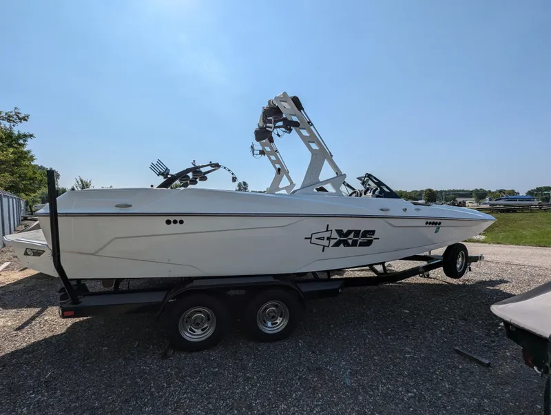 Slide: The Image of 2019 Axis A22 boat on trailer, side view, outdoors on gravel surface. - 0