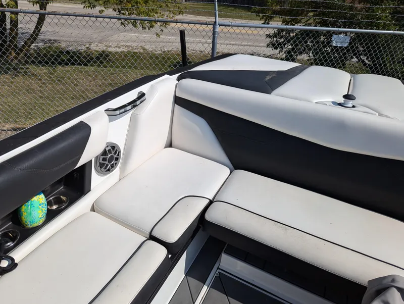 Slide: The Image of 2019 Axis A22 boat interior with white and black seating, cup holders, and speaker. - 11