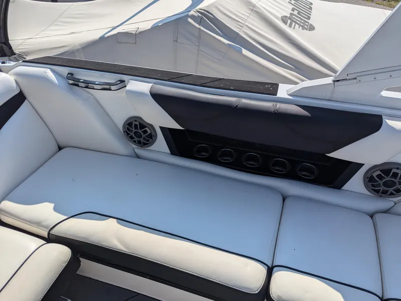 Slide: The Image of 2019 Axis A22 boat interior with white seating and speaker system. - 13