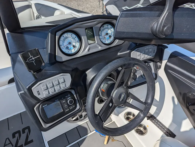 Slide: The Image of 2019 Axis A22 boat dashboard with steering wheel, gauges, and control panel. - 15