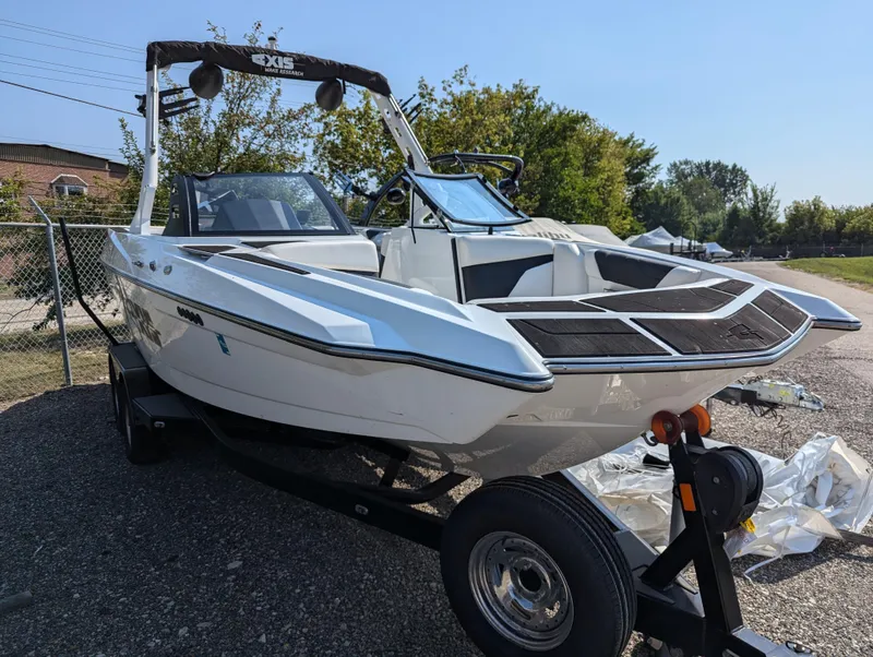 Slide: The Image of 2019 Axis A22 boat on trailer, parked outdoors, showcasing sleek design and modern features. - 2