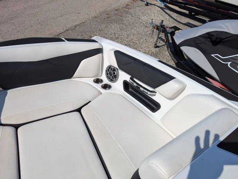 Slide: The Image of 2019 Axis A22 boat interior with white and black seating, speaker, and cup holders. - 6