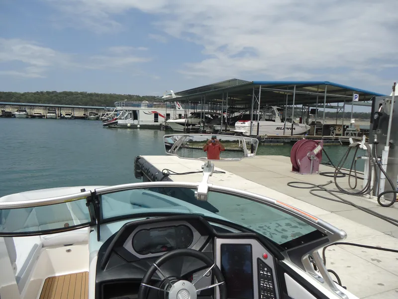 Slide: The Image of 2021 MasterCraft XStar boat docked at a marina with clear skies. - 19
