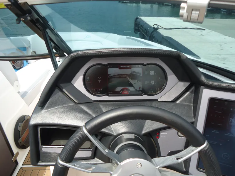 Slide: The Image of 2021 MasterCraft XStar dashboard with steering wheel and digital display at marina. - 20