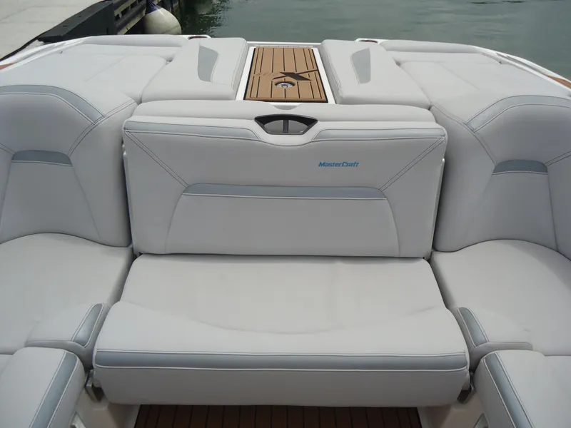 Slide: The Image of 2021 MasterCraft XStar boat interior with white cushioned seating and wooden accents. - 23