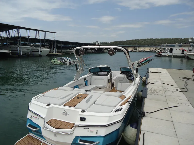 Slide: The Image of 2021 MasterCraft XStar boat docked at a marina with clear skies. - 5