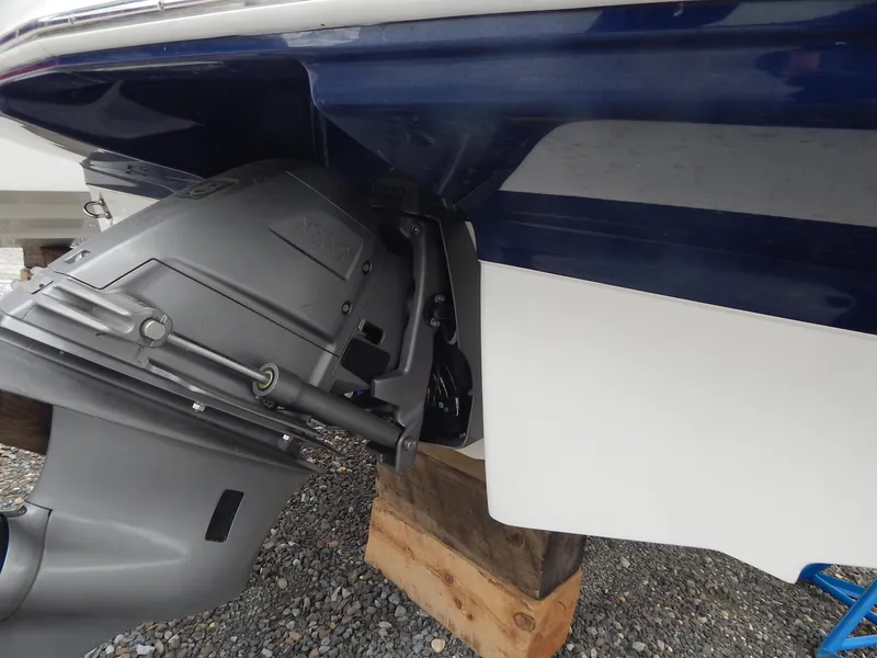 Slide: The Image of 2021 Chaparral 23 SSi boat stern drive on gravel, supported by wooden blocks. - 4