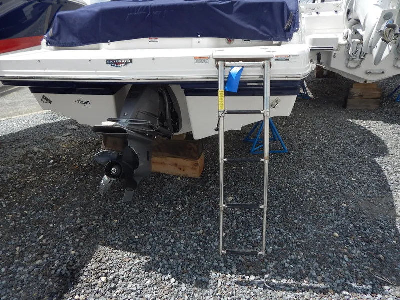 Slide: The Image of 2021 Chaparral 23 SSi boat stern with outboard motor and boarding ladder on gravel. - 44