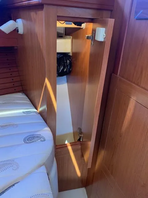 Slide: The Image of 2008 Mainship Pilot 34 cabin interior with wooden cabinetry and cozy seating. - 11