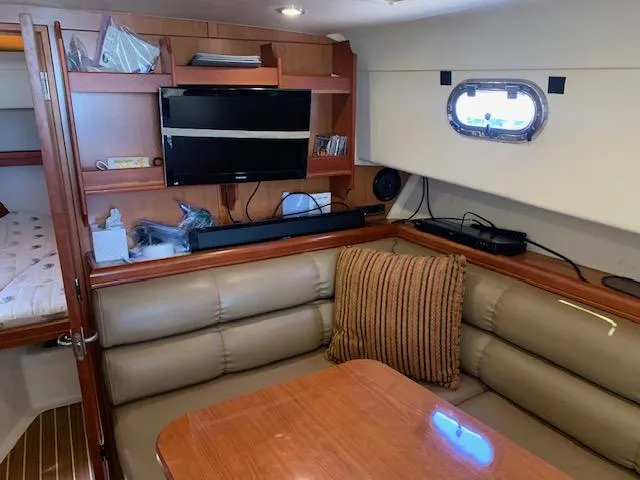 Slide: The Image of 2008 Mainship Pilot 34 interior with leather seating, wooden table, and mounted TV. - 13