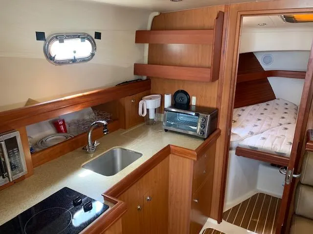Slide: The Image of 2008 Mainship Pilot 34 interior with kitchenette and cozy sleeping area. - 14