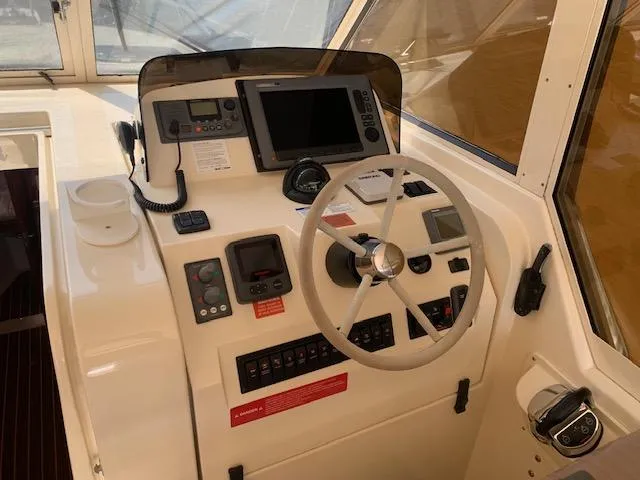 Slide: The Image of 2008 Mainship Pilot 34 helm with steering wheel, navigation controls, and electronic displays. - 16