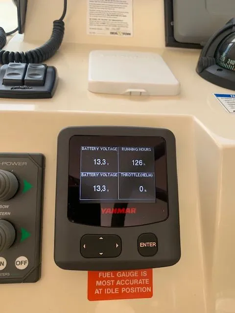 Slide: The Image of 2008 Mainship Pilot 34 dashboard with Yanmar display showing battery voltage and running hours. - 25