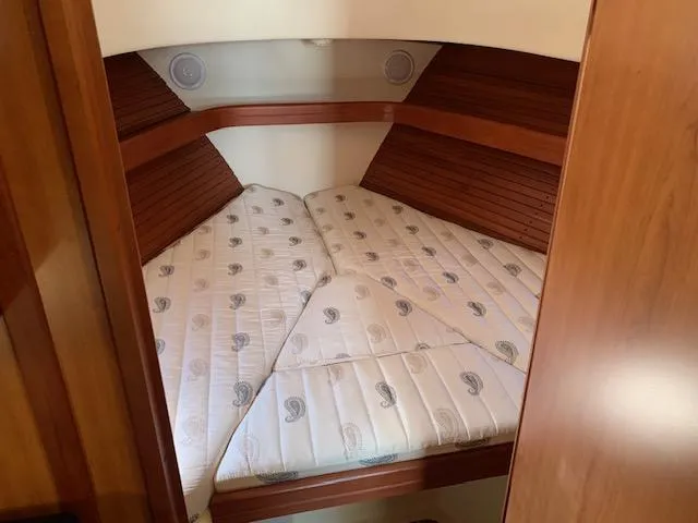 Slide: The Image of 2008 Mainship Pilot 34 cabin with cozy V-berth and wooden accents. - 9