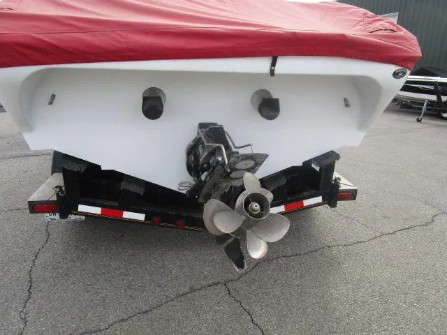 Slide: The Image of 2001 Baja 292 Islander boat with red cover on trailer, showing propeller and stern. - 3