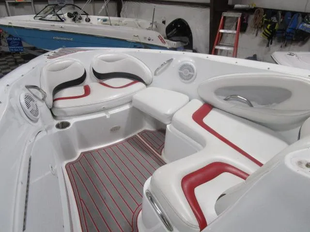 Slide: The Image of 2001 Baja 292 Islander boat interior with white and red seating, gray flooring, and cup holders. - 9