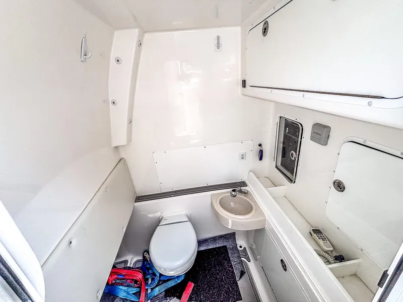 Slide: The Image of 2022 Invincible 36 Open Fisherman boat bathroom with toilet, sink, and storage cabinets. - 10