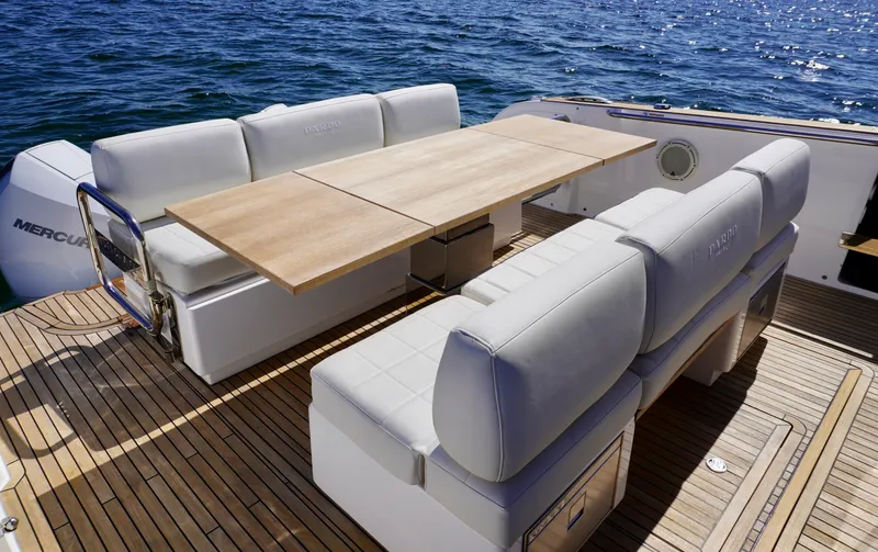 Slide: The Image of Luxury seating area on 2020 Pardo Yachts 38, featuring elegant wooden table and cushioned benches. - 14