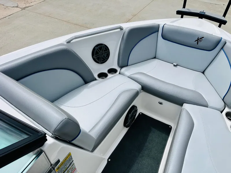 Slide: The Image of 2016 MasterCraft X30 boat interior with gray seating and built-in speakers. - 12