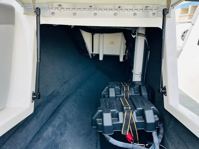 Slide: The Image of 2016 MasterCraft X30 boat storage compartment with battery and wiring. - 24