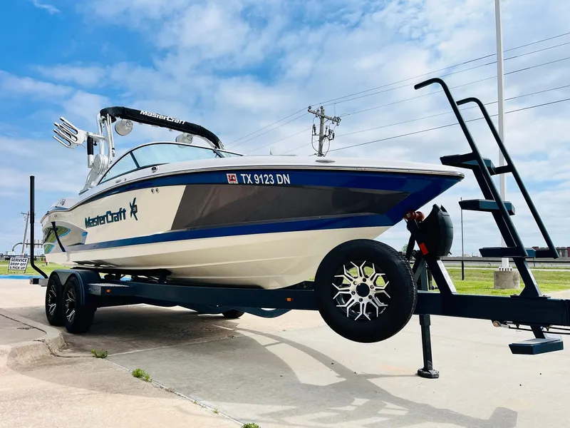 Slide: The Image of 2016 MasterCraft X30 boat on trailer, displayed outdoors under a blue sky. - 3