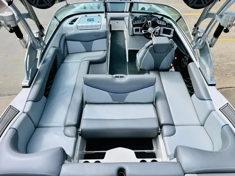 Slide: The Image of 2016 MasterCraft X30 boat interior with gray seating and modern dashboard. - 30