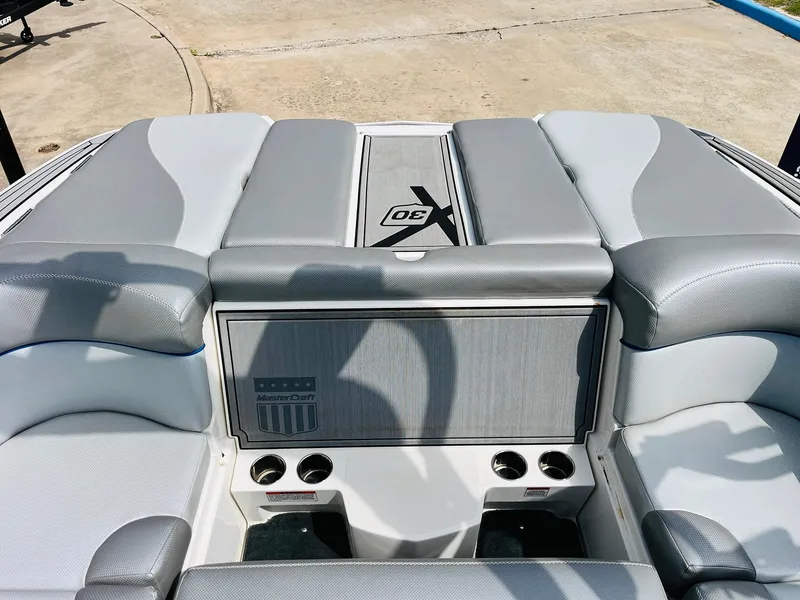 Slide: The Image of 2016 MasterCraft X30 boat interior with gray seating and cup holders. - 32