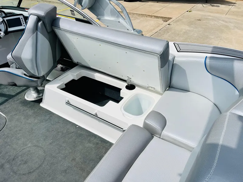 Slide: The Image of 2016 MasterCraft X30 boat interior with open storage compartment and gray seating. - 35