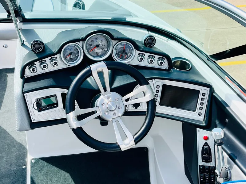 Slide: The Image of 2016 MasterCraft X30 boat dashboard with steering wheel, gauges, and control panel. - 39
