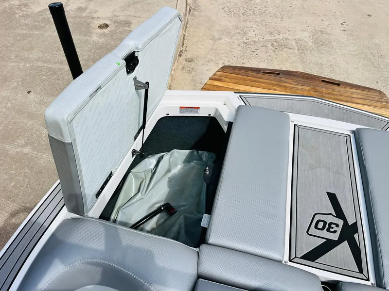 Slide: The Image of 2016 MasterCraft X30 boat interior with open storage compartment and sleek seating design. - 44
