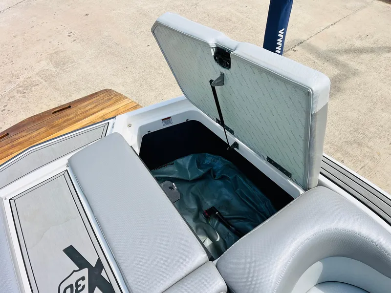 Slide: The Image of 2016 MasterCraft X30 boat storage compartment with open lid, showcasing interior space. - 45