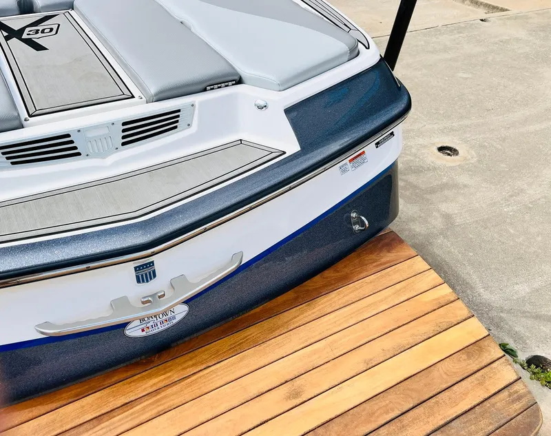 Slide: The Image of 2016 MasterCraft X30 boat stern on wooden dock. - 49
