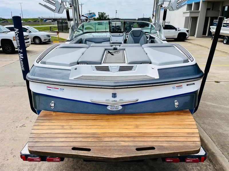 Slide: The Image of 2016 MasterCraft X30 boat with teak swim platform, parked at a marina. - 8
