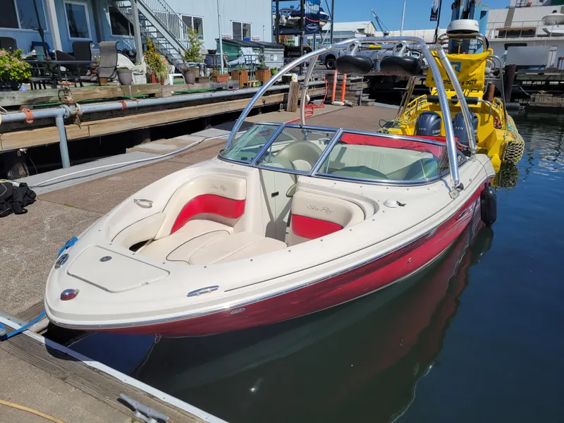 Slide: The Image of 2005 Sea Ray 200 Select boat docked at marina, featuring red and white design. - 1