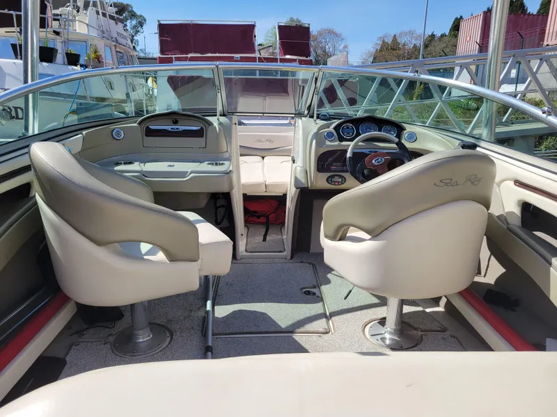 Slide: The Image of 2005 Sea Ray 200 Select boat interior with beige seating and modern dashboard. - 10