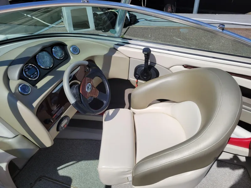 Slide: The Image of Interior of 2005 Sea Ray 200 Select boat with beige seating and dashboard controls. - 13