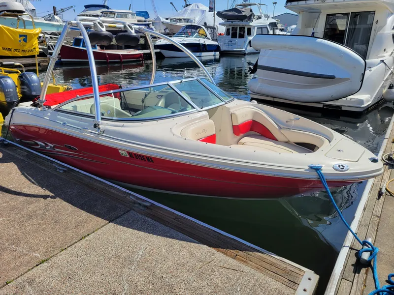 Slide: The Image of 2005 Sea Ray 200 Select boat docked at marina, featuring red and white design. - 2