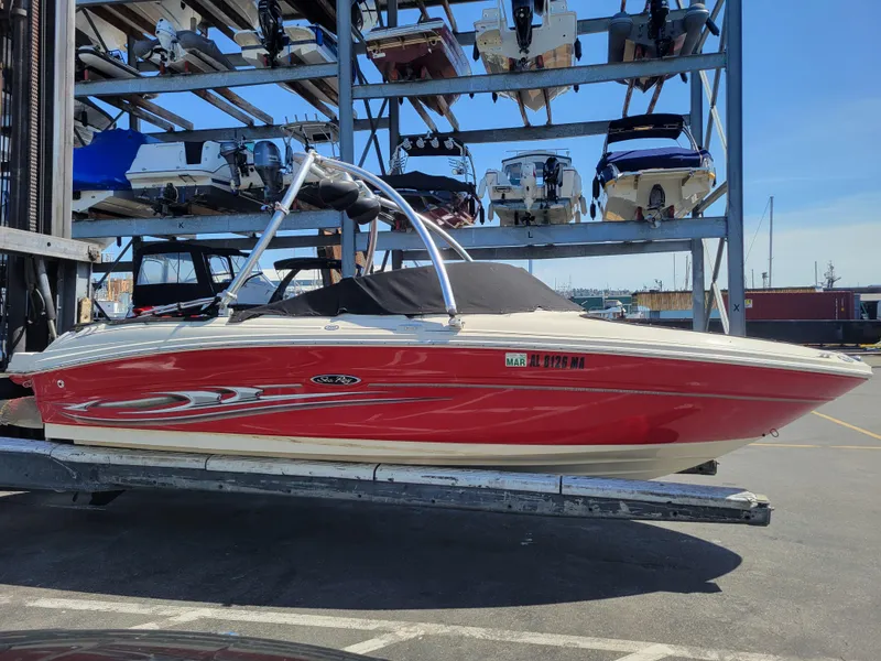 Slide: The Image of 2005 Sea Ray 200 Select boat in storage, red hull, marina background. - 24
