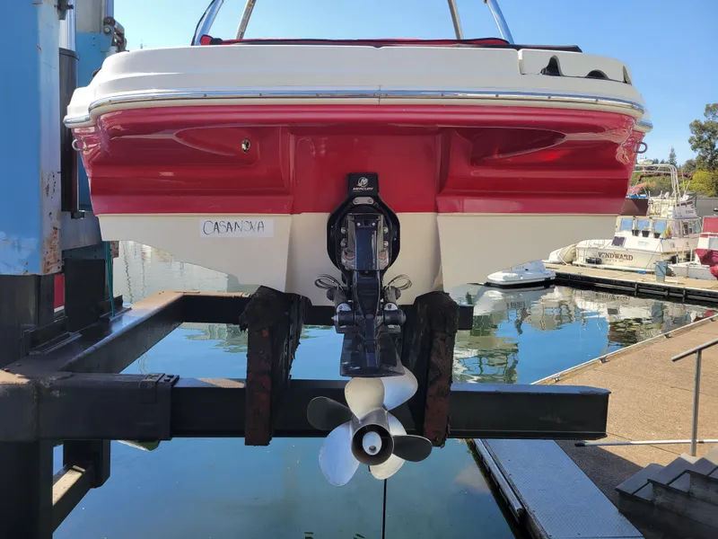 Slide: The Image of 2005 Sea Ray 200 Select boat on lift, red and white hull, marina background. - 26