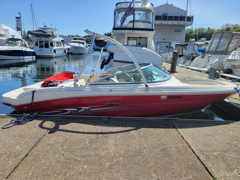 Slide: The Image of 2005 Sea Ray 200 Select boat docked at a marina, surrounded by other vessels. - 3