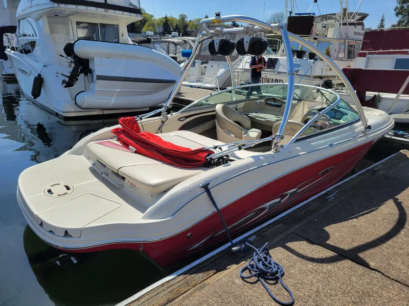 Slide: The Image of 2005 Sea Ray 200 Select boat docked at marina, featuring red and white design. - 4