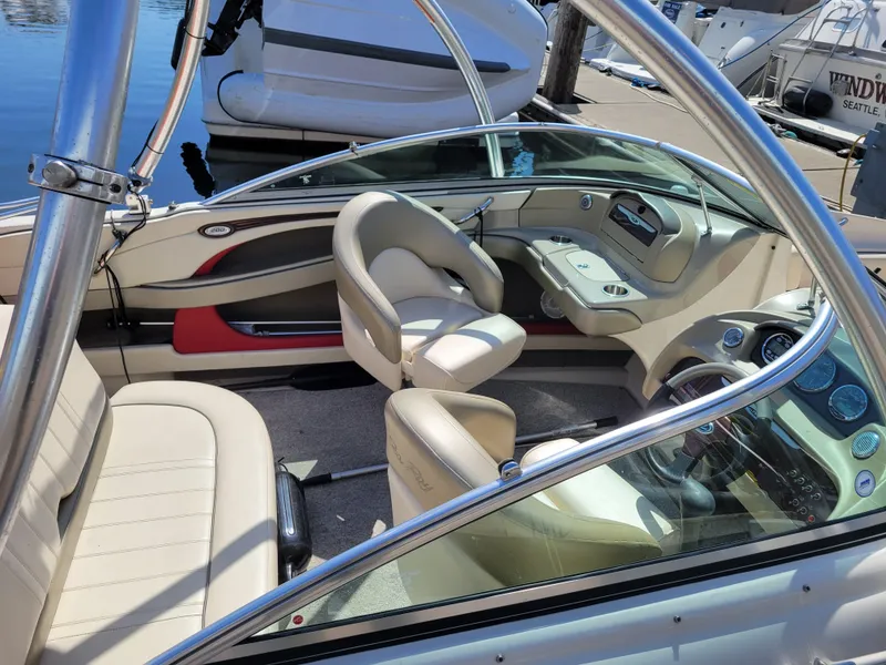 Slide: The Image of 2005 Sea Ray 200 Select boat interior with beige seating and sleek dashboard design. - 7