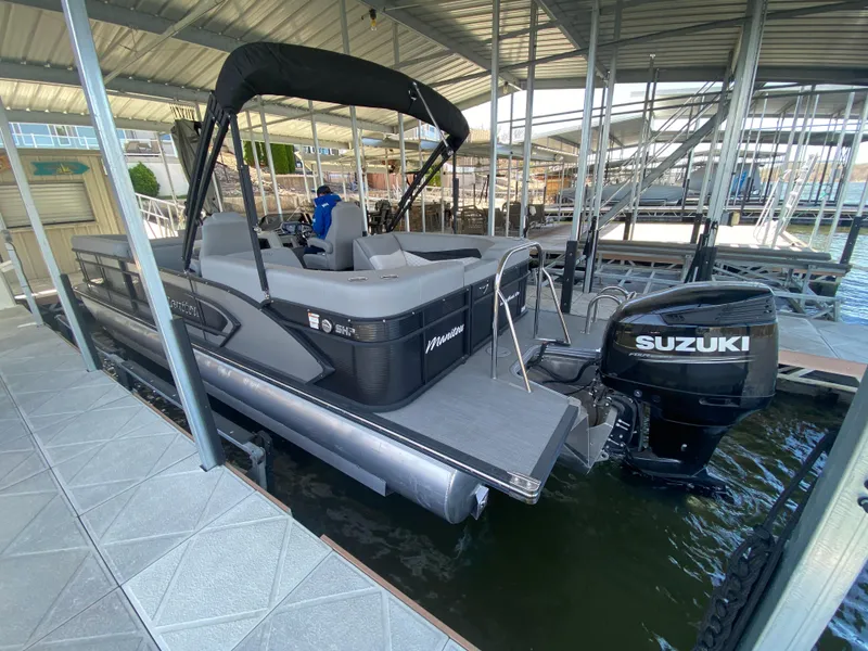 Slide: The Image of 2021 Manitou 25 Encore RF SHP Twin pontoon boat with Suzuki outboard motor in dock. - 12