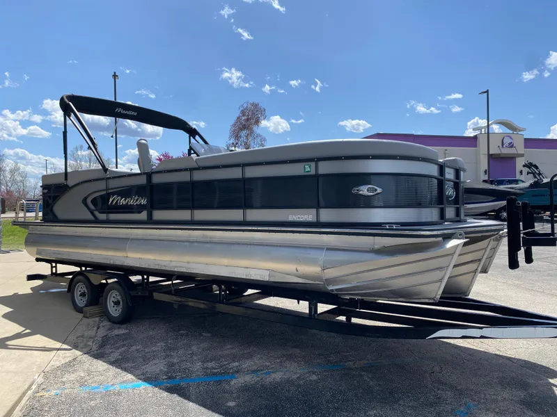 Slide: The Image of 2021 Manitou 25 Encore RF SHP Twin pontoon boat on trailer under blue sky. - 16