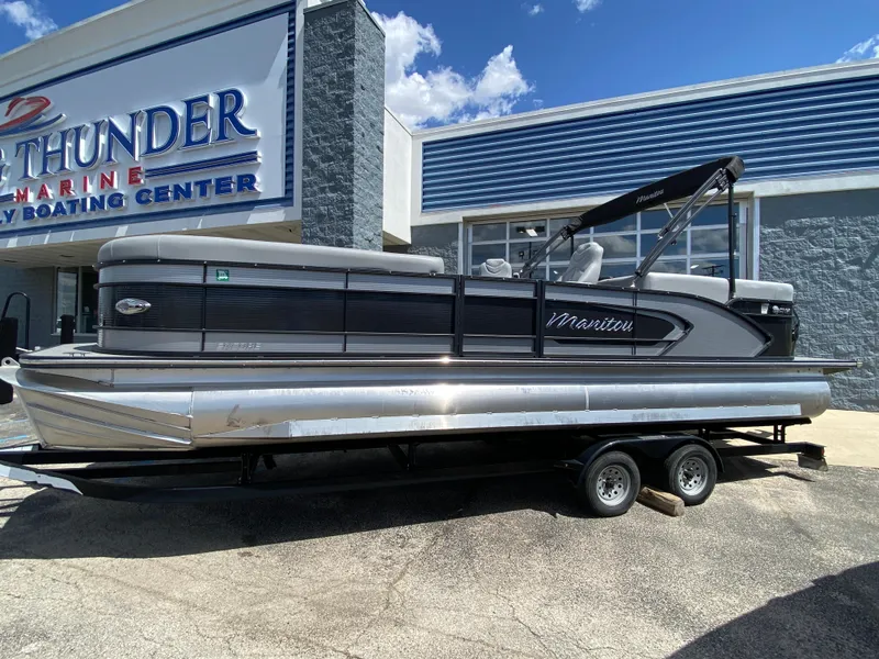 Slide: The Image of 2021 Manitou 25 Encore RF SHP Twin pontoon boat on trailer outside dealership. - 21